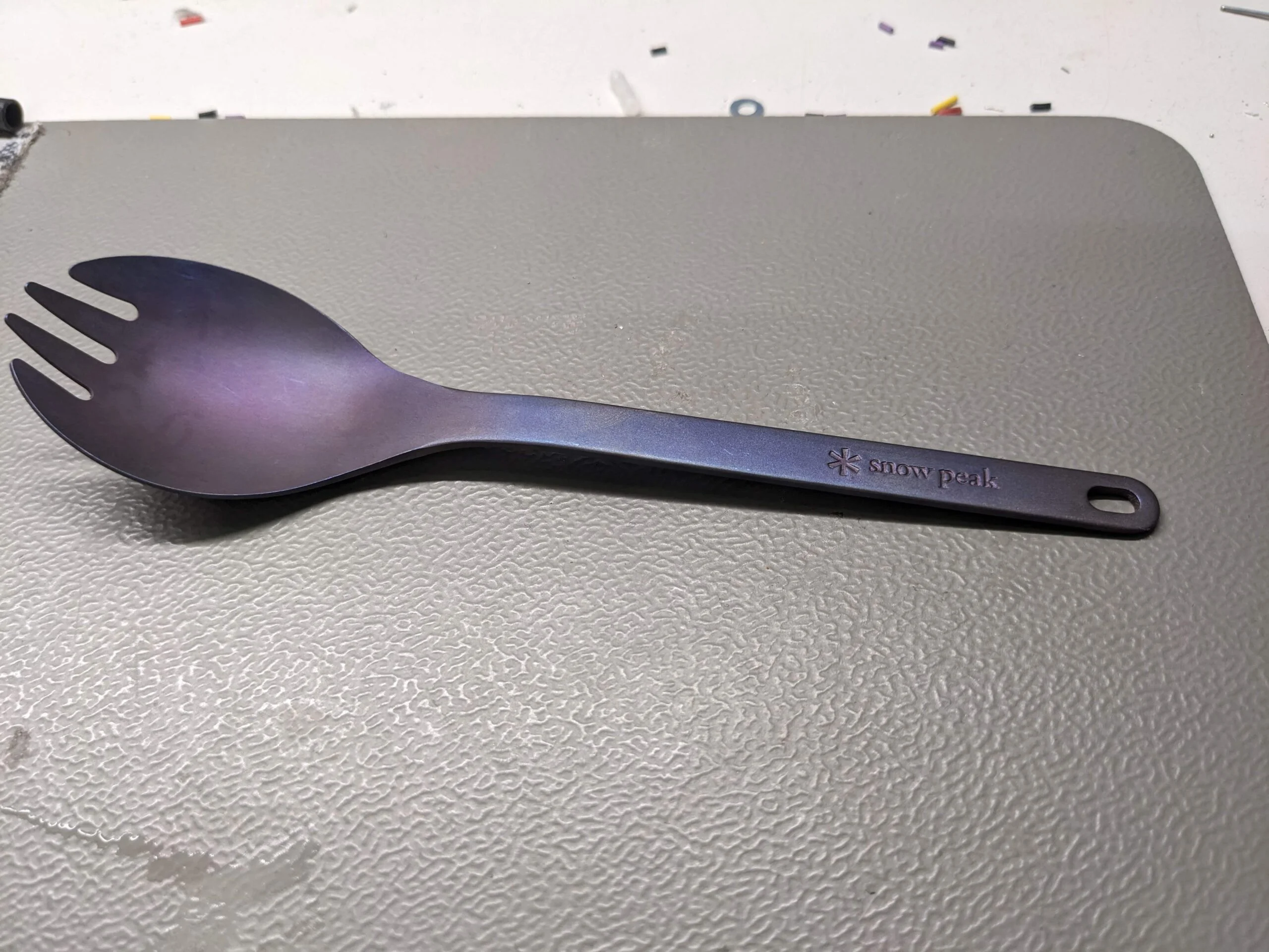 A purple spork with a blue sheen